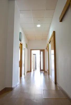 an empty hallway in a building with a clock on the wall at Albergue Melide in Melide