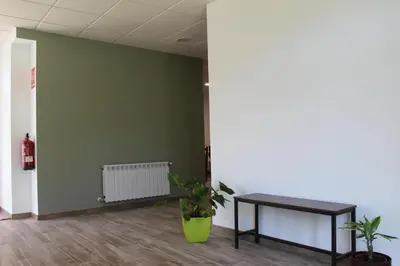 an empty room with a table and plants in it at Pensión Albergue O Pedregal in Lourenzá