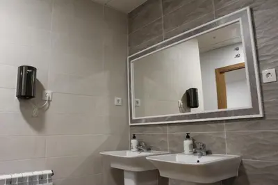a bathroom with two sinks and a mirror at Pensión Albergue O Pedregal in Lourenzá