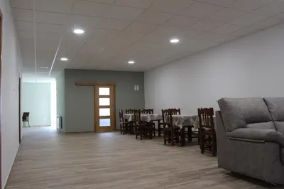 a dining room with a table and chairs and a couch at Pensión Albergue O Pedregal in Lourenzá