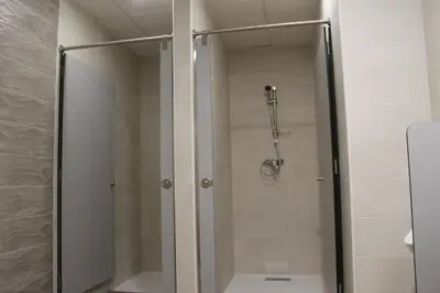 a shower with a glass door in a bathroom at Pensión Albergue O Pedregal in Lourenzá