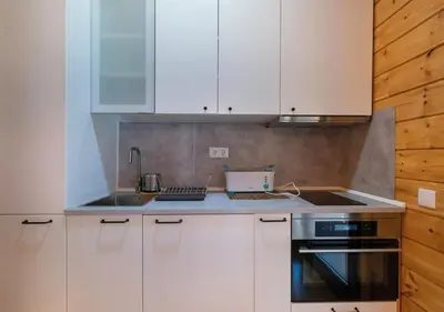 a kitchen with white cabinets and a sink and a stove at Estudios Galende in Galende