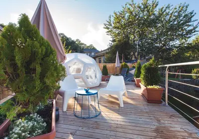 a patio with two white chairs and an umbrella at Estudios Galende in Galende