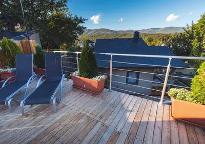 a deck with two chairs and plants on it at Estudios Galende in Galende