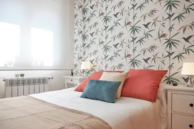 a bedroom with a bed with red and blue pillows at Peregrina Pension 3 in O Pedrouzo