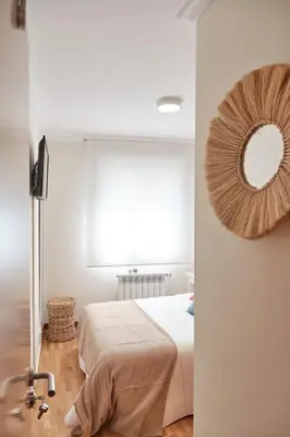 a bedroom with a bed and a mirror on the wall at Peregrina Pension 3 in O Pedrouzo