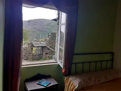 a bedroom with a window with a view of a mountain at Albergue ESCANLAR in Lugo
