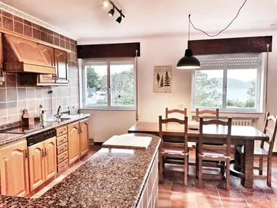 a kitchen with a table and a dining room at Casa Courcelles - Viveiro in Viveiro