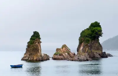 two small islands in the water with a boat at Casa Courcelles - Viveiro in Viveiro