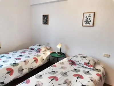 a bedroom with two beds and a lamp on a table at Casa Courcelles - Viveiro in Viveiro