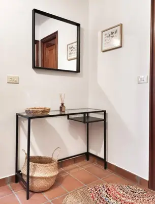 a mirror on a wall next to a table with a basket at Casa Courcelles - Viveiro in Viveiro