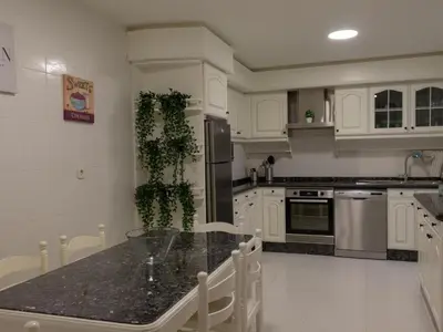 a kitchen with white cabinets and a black counter top at Housingcoruña sada playa in Sada