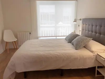 a bedroom with a large bed with a large window at Housingcoruña sada playa in Sada