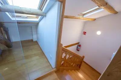 an attic room with a glass door and a staircase at Casa Alameda 33 de Casas Das Figueiras en Ría Eo-Ribadeo in Castropol