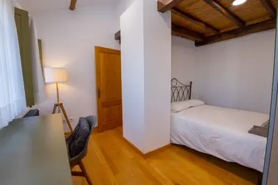 a bedroom with a bed and a desk with a lamp at Casa Alameda 33 de Casas Das Figueiras en Ría Eo-Ribadeo in Castropol