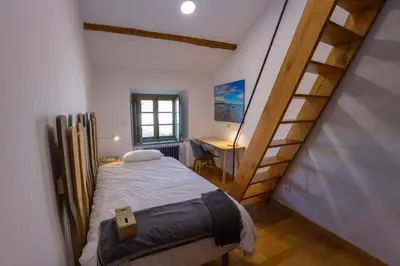 a small bedroom with a bed and a desk at Casa Alameda 33 de Casas Das Figueiras en Ría Eo-Ribadeo in Castropol
