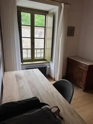 a table and a chair in a room with a window at Casa Alameda 33 de Casas Das Figueiras en Ría Eo-Ribadeo in Castropol