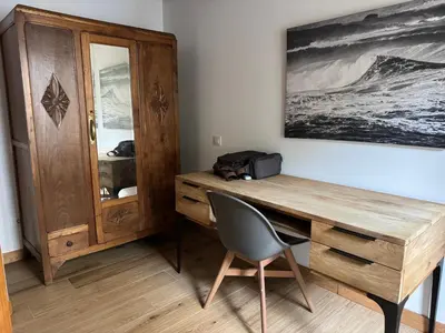 a wooden desk with a chair next to a wooden cabinet at Casa Alameda 33 de Casas Das Figueiras en Ría Eo-Ribadeo in Castropol