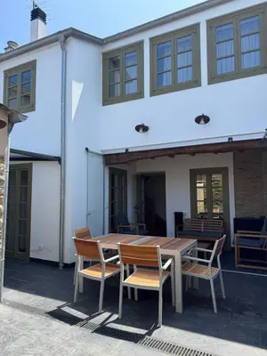 a wooden table and chairs in front of a white building at Casa Alameda 33 de Casas Das Figueiras en Ría Eo-Ribadeo in Castropol