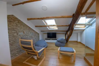 a living room with a chair and a tv at Casa Alameda 33 de Casas Das Figueiras en Ría Eo-Ribadeo in Castropol