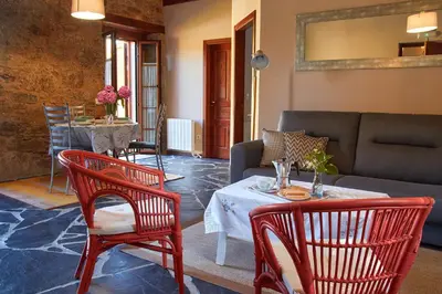 a living room with a couch and a table and chairs at Escola de Bieite in Boimorto