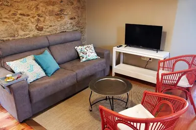 a living room with a couch and a tv at Escola de Bieite in Boimorto