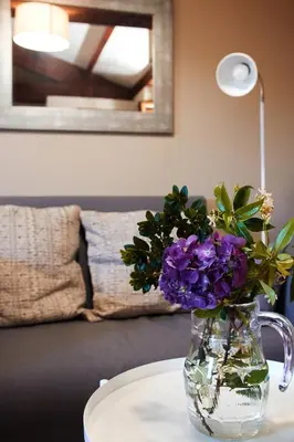 a vase of purple flowers sitting on a table at Escola de Bieite in Boimorto