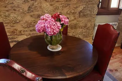 a vase of pink flowers sitting on a wooden table at Escola de Bieite in Boimorto