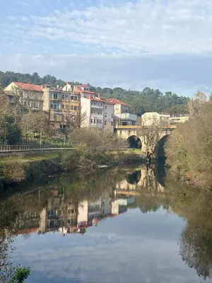 a bridge over a river with buildings in the background at Casa Fidalgo in Ribadavia