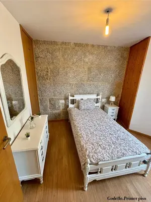 a bedroom with a bed and a vanity and a mirror at Casa Fidalgo in Ribadavia