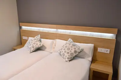 a bedroom with two beds with white sheets and pillows at Alda Catedral in Santiago de Compostela