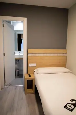 a bedroom with a bed and a bathroom with a sink at Alda Catedral in Santiago de Compostela