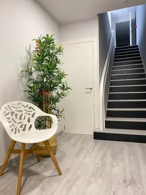 a room with a white chair and a staircase at Alda Catedral in Santiago de Compostela