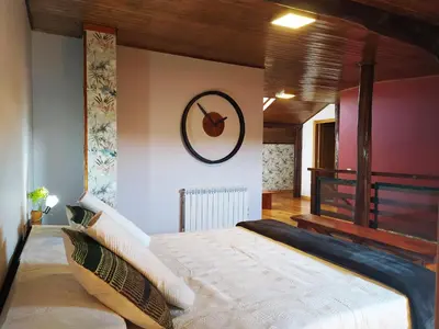 a bedroom with a bed and a clock on the wall at Casa das Pozas 2 in Monforte de Lemos