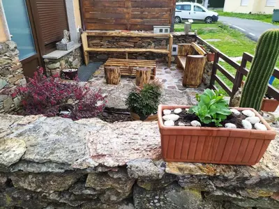 a garden with a bench and a stone wall at Casa das Pozas 2 in Monforte de Lemos
