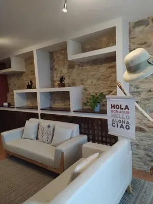 a living room with a couch and a hat on the wall at Casa das Pozas 2 in Monforte de Lemos