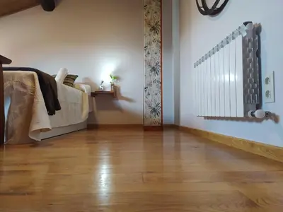 a room with a bed and a wooden floor at Casa das Pozas 2 in Monforte de Lemos