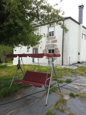 a red table in front of a house at CASA ISAURA DE PENA Camino Primitivo in Pacio