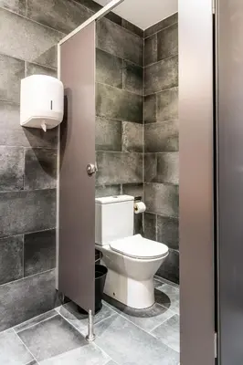 a bathroom with a toilet in a stall at Four Rooms Hostel in Lugo