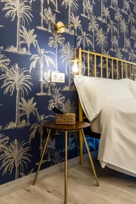 a bedroom with a blue wall with palm trees wallpaper at Four Rooms Hostel in Lugo