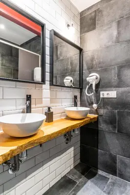 two sinks in a bathroom with two mirrors at Four Rooms Hostel in Lugo