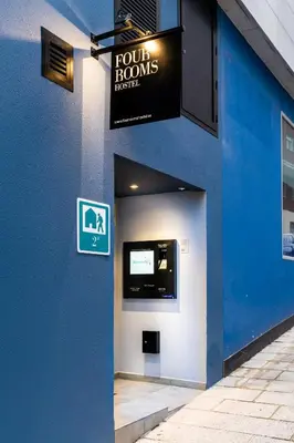 a blue building with a sign for a toilet room at Four Rooms Hostel in Lugo