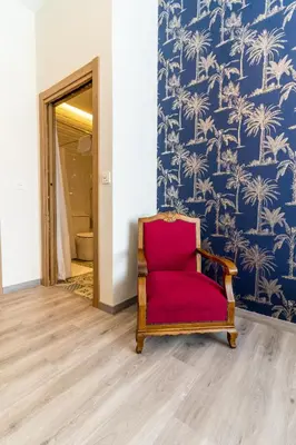 a red chair in a room with blue and white wallpaper at Four Rooms Hostel in Lugo