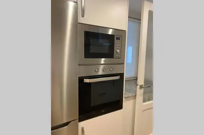 a kitchen with a stainless steel oven with a microwave at El Taller de Doña Remedios in Mondoñedo
