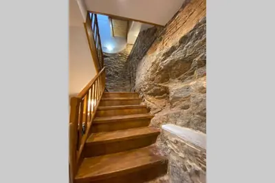 a staircase in a building with a stone wall at El Taller de Doña Remedios in Mondoñedo