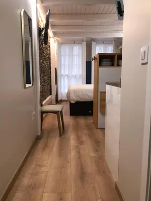 a small room with a bed and a wooden floor at Apartamento completamente equipado en Pontedeume. in Puentedeume