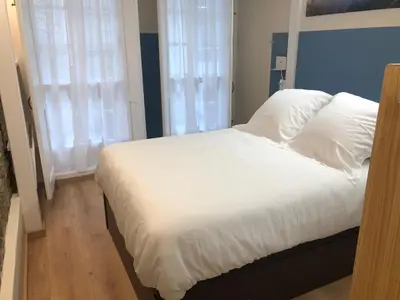 a bed with white sheets and pillows in a bedroom at Apartamento completamente equipado en Pontedeume. in Puentedeume