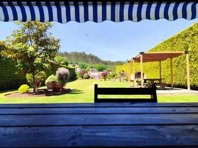 a stone barbecue grill sitting in the grass at Finca O Loureiro in Amés
