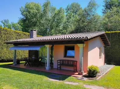 a small cottage with a table and chairs in a yard at Finca O Loureiro in Amés