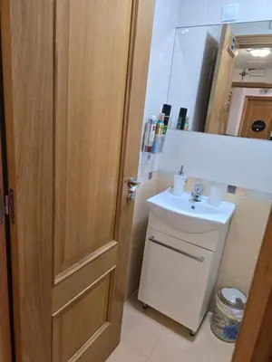 a bathroom with a sink and a wooden door at Pension Myriam O PEDROUZO in O Pedrouzo